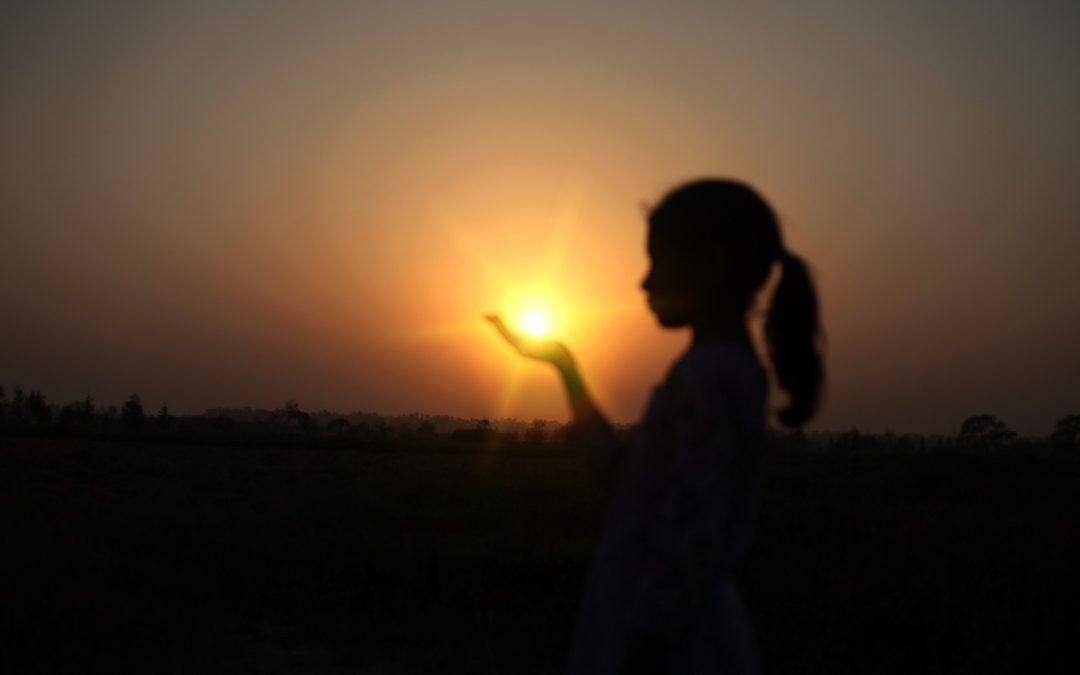 child holding the light in her hands