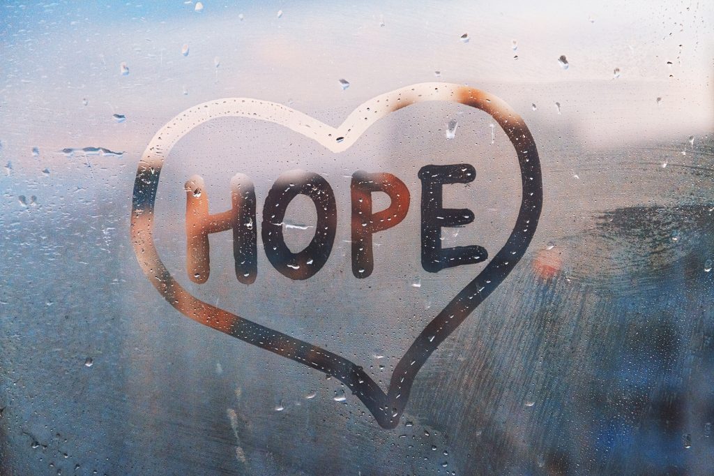 hope written in a heart drawn on foggy window