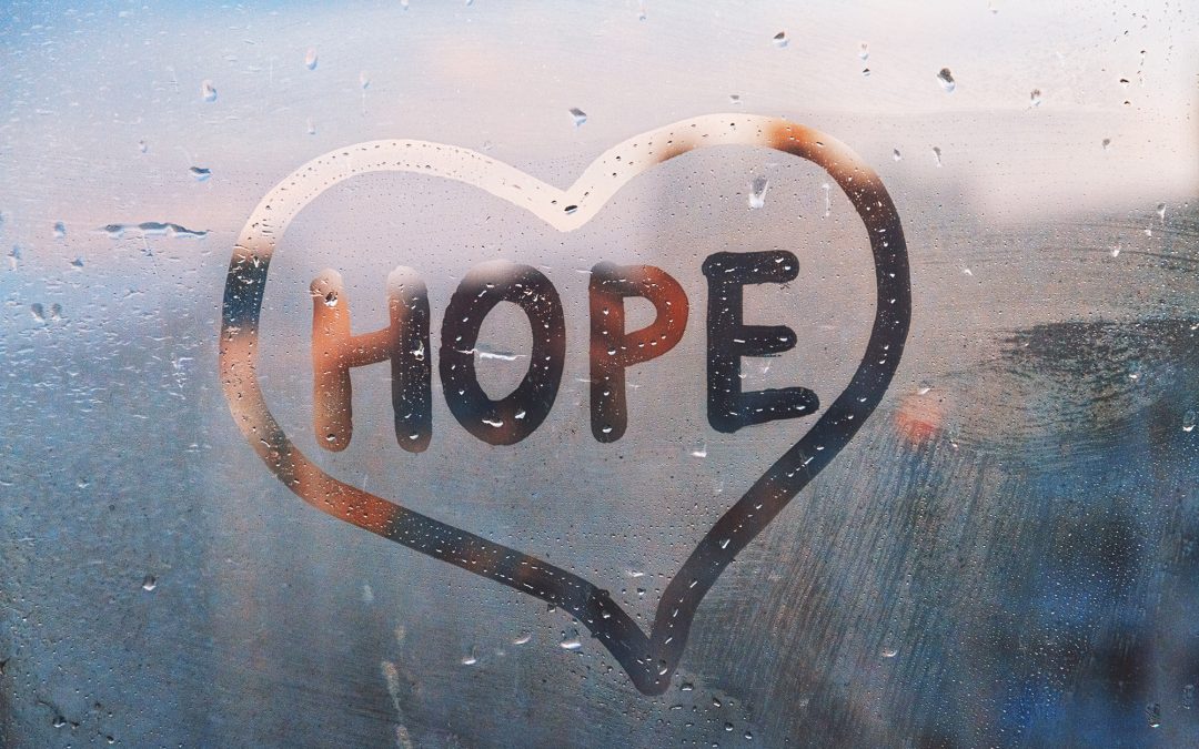 hope written in a heart drawn on foggy window